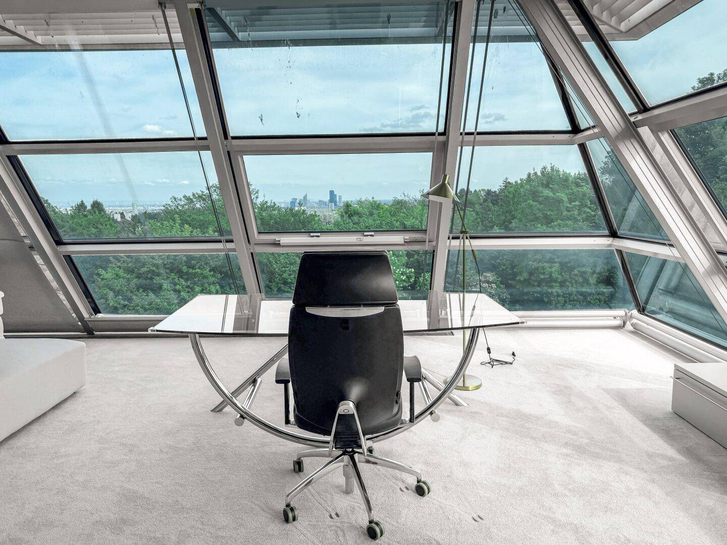 Exklusives Büro mit Glasfassade, Panoramablick und modernem Schreibtisch.