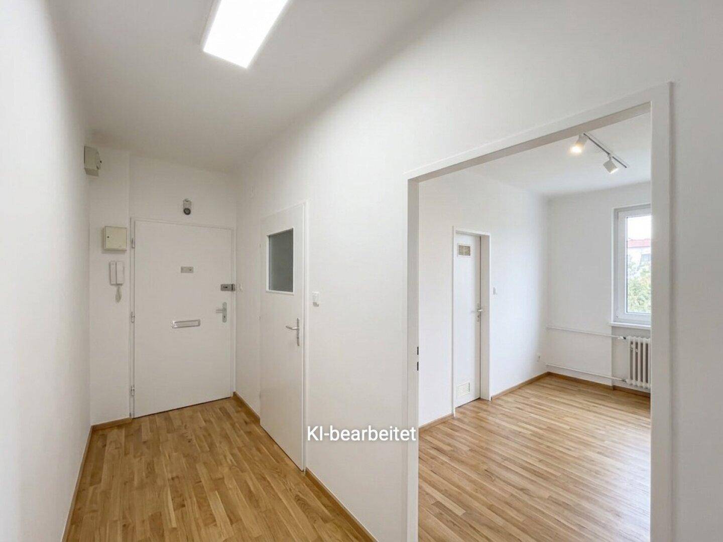 Heller Eingangsbereich mit Holzboden und Zugang zu weiteren Zimmern, die viel Licht bieten.