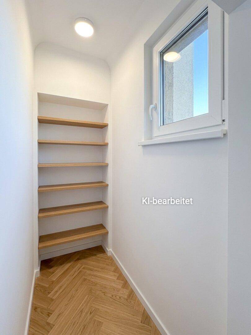 Praktischer Abstellraum mit eingebauten Holzregalen und einem Fenster für natürliche Belüftung.