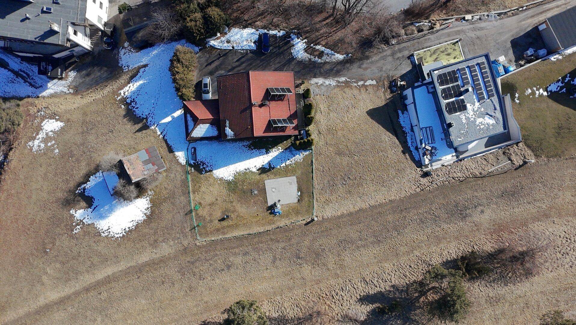 Luftaufnahme des Anwesens im Winter mit schneebedeckten Flächen und umliegender Natur.