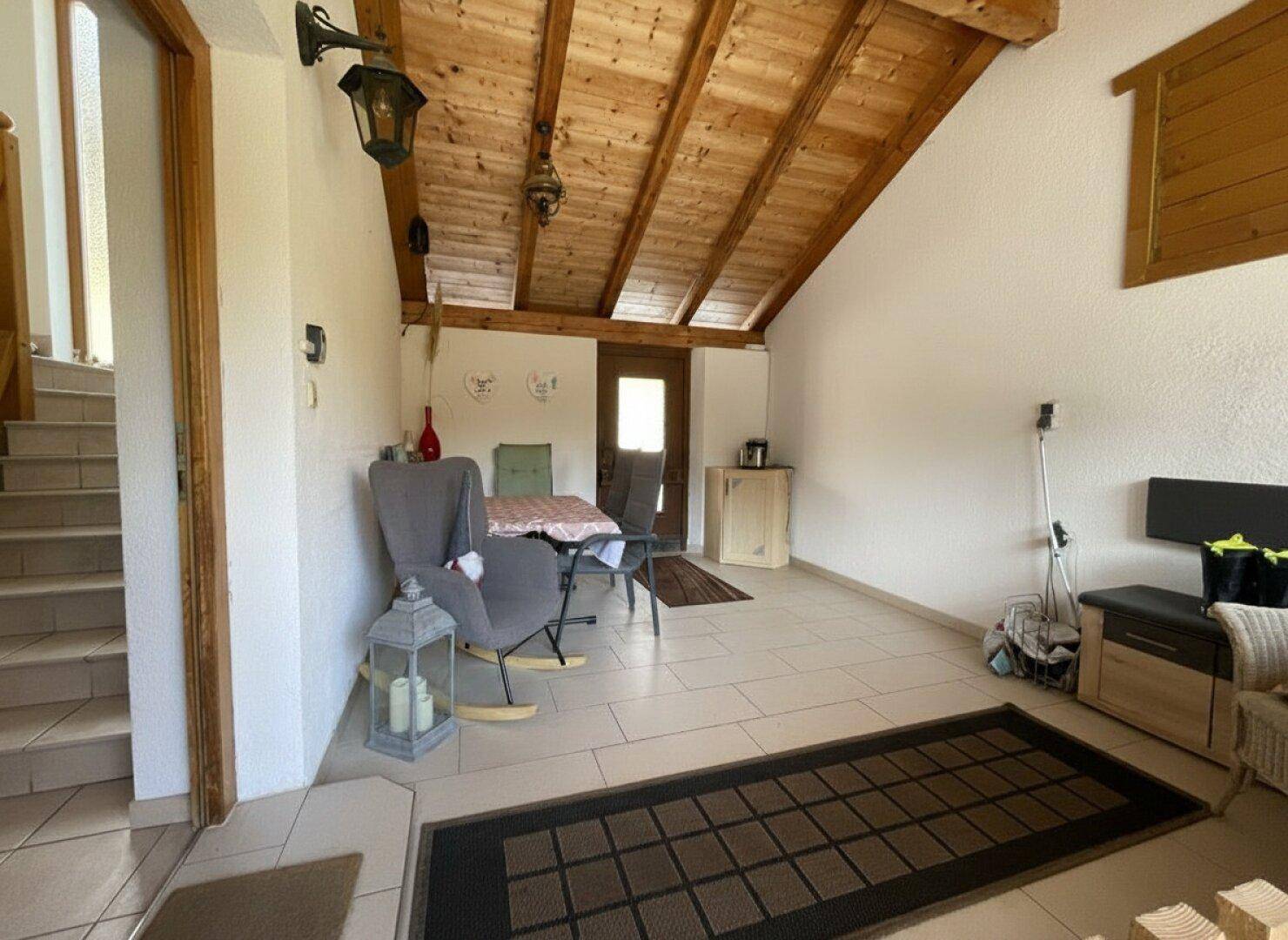 Ausgebauter Dachboden mit sichtbaren Holzbalken und einem gemütlichen Sitzbereich.