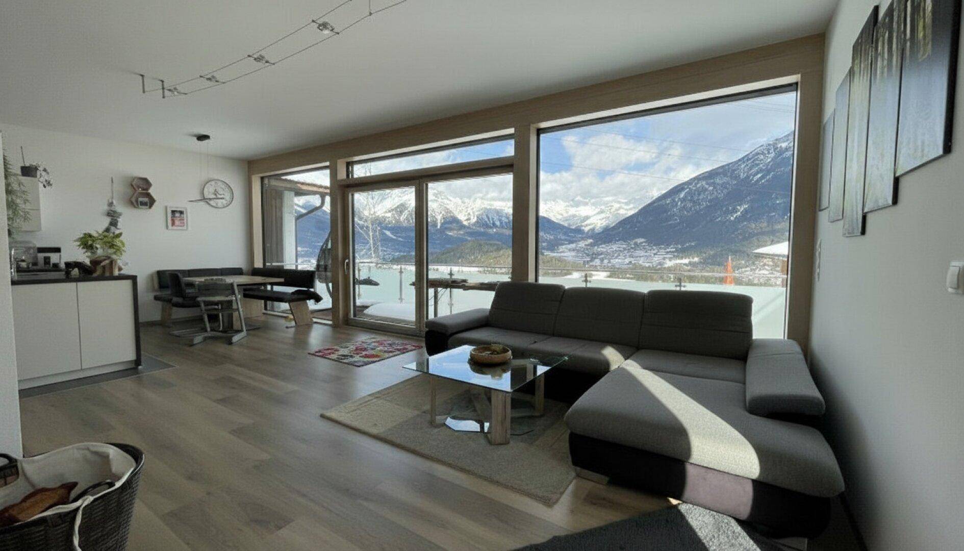 Helles Wohn-Esszimmer mit großen Fenstern und beeindruckendem Bergblick.
