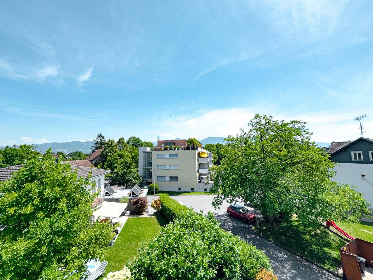 Panoramablick über die Wohnsiedlung mit viel Grün, Häusern und einem Spielplatz im Vordergrund.