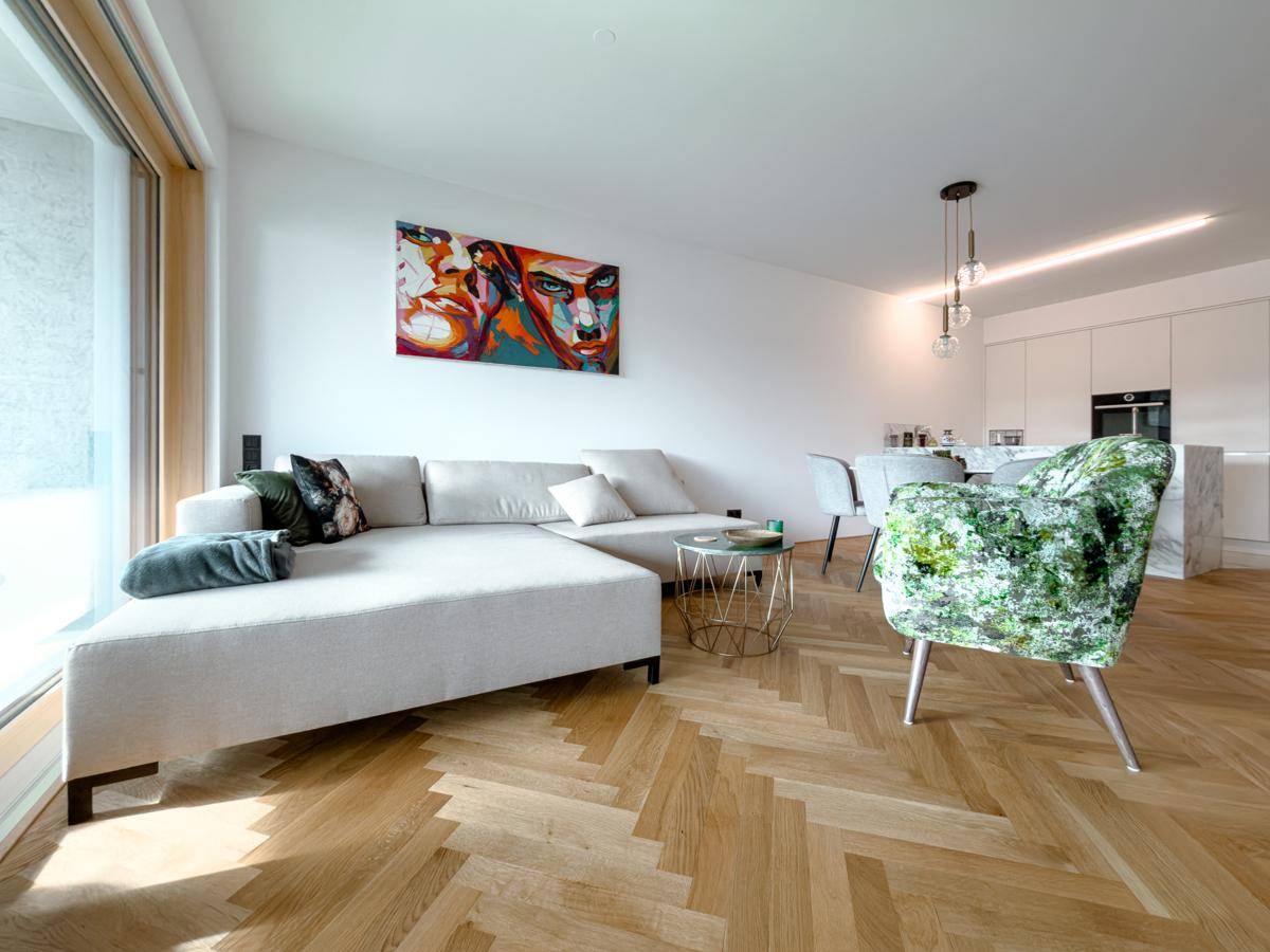 Offener Wohnbereich mit stilvoller Einrichtung, bequemer Couch und nahtlosem Übergang zur Küche.