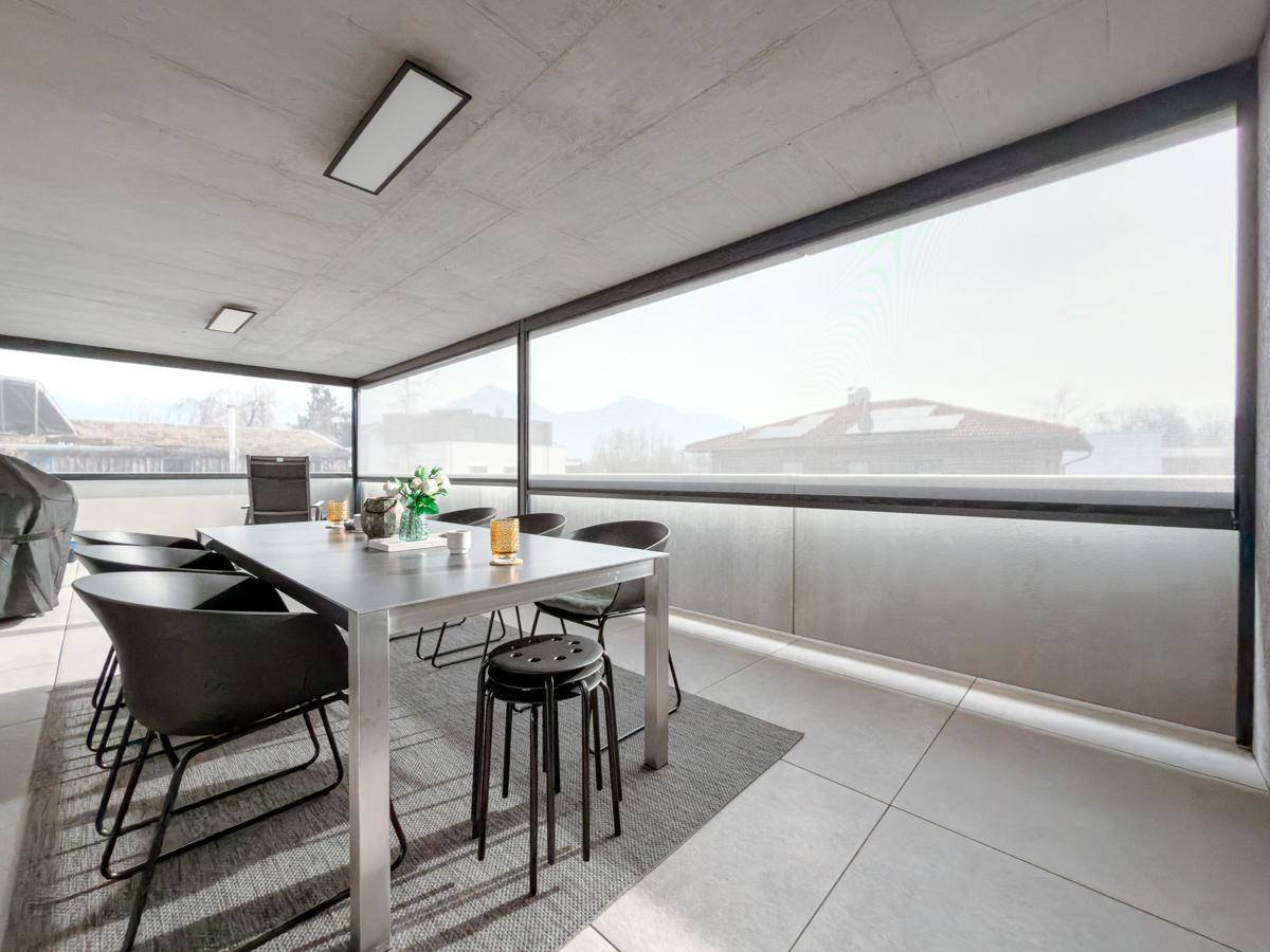 Große, überdachte Terrasse mit Essbereich und Panoramablick auf die umliegende Berglandschaft.