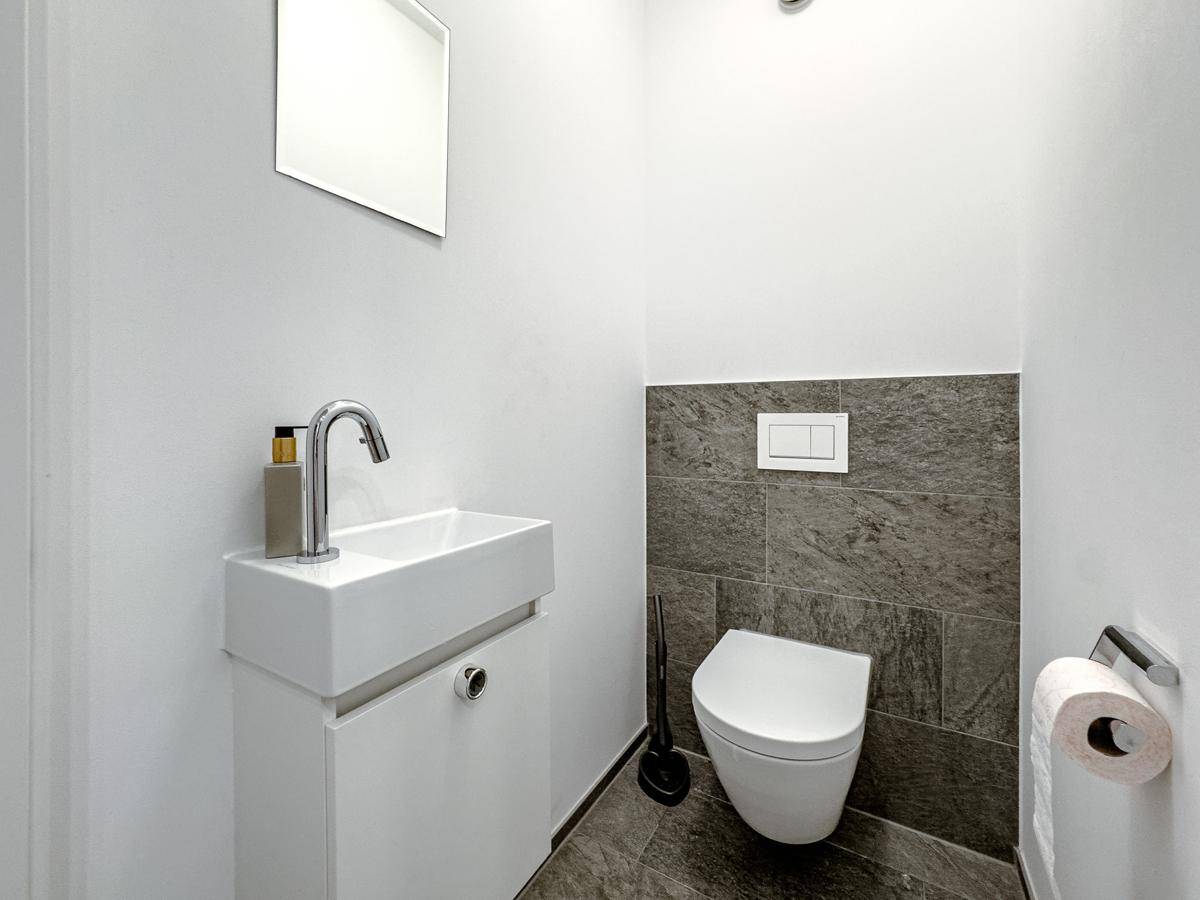 Kleines Gäste-WC mit modernem Waschtisch und wandhängendem WC, minimalistisch und platzsparend.