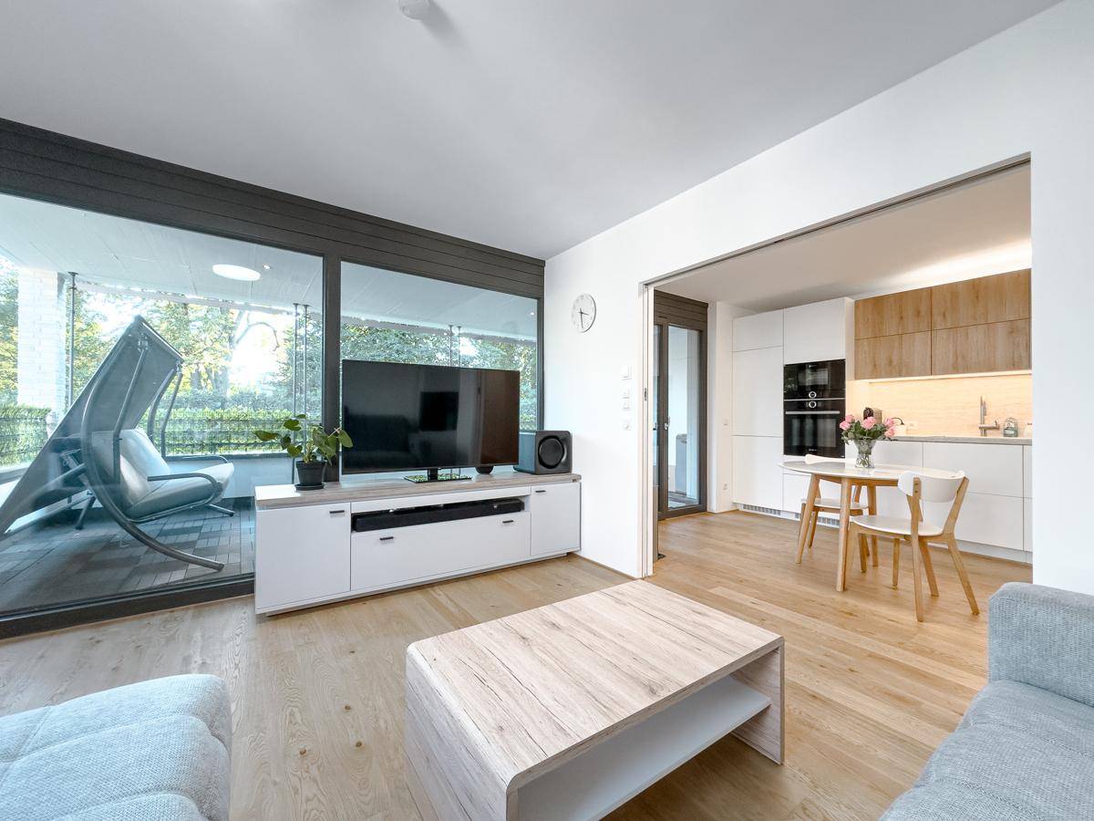 Heller Wohnbereich mit Zugang zu einem großen Balkon und offener Verbindung zur Küche.