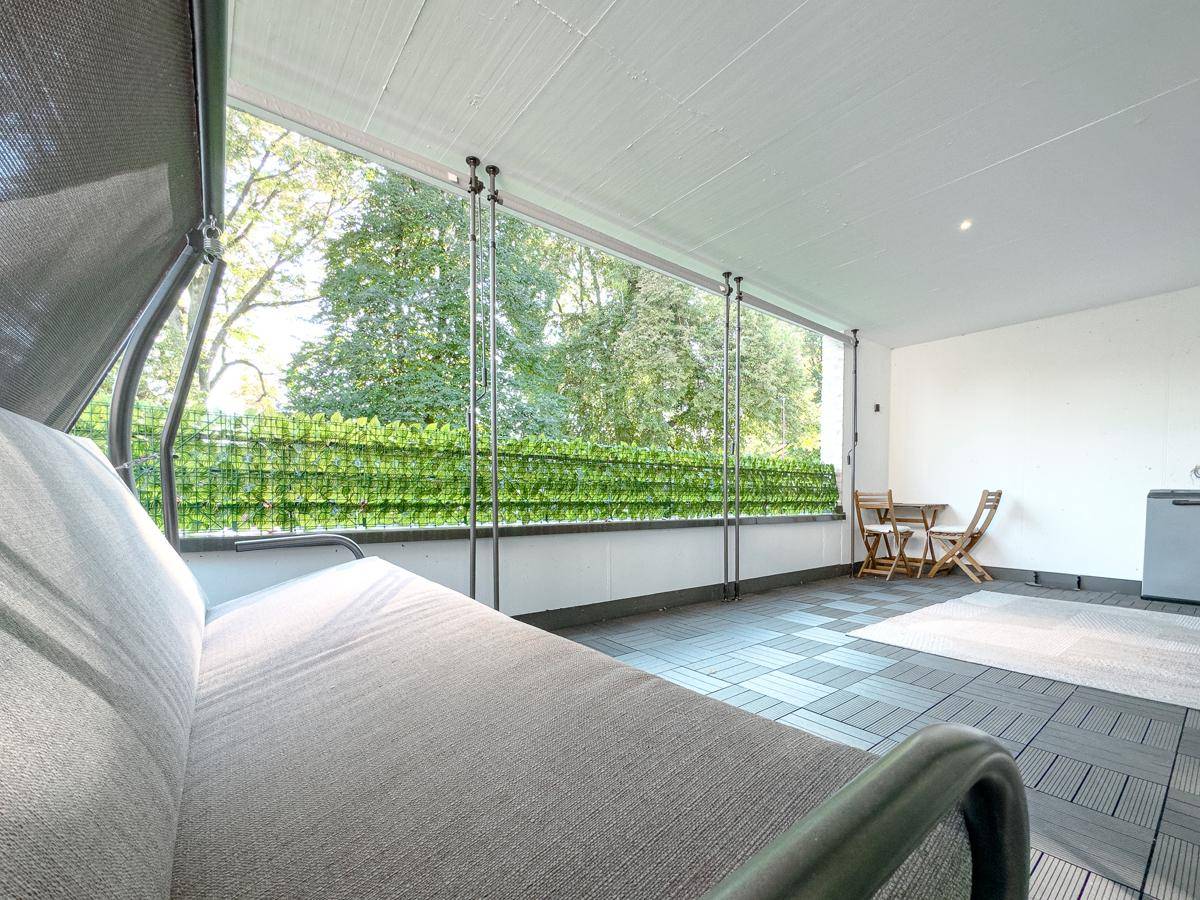 Geräumiger Balkon mit Lounge-Möbeln und Blick ins Grüne, ideal zum Entspannen im Freien.