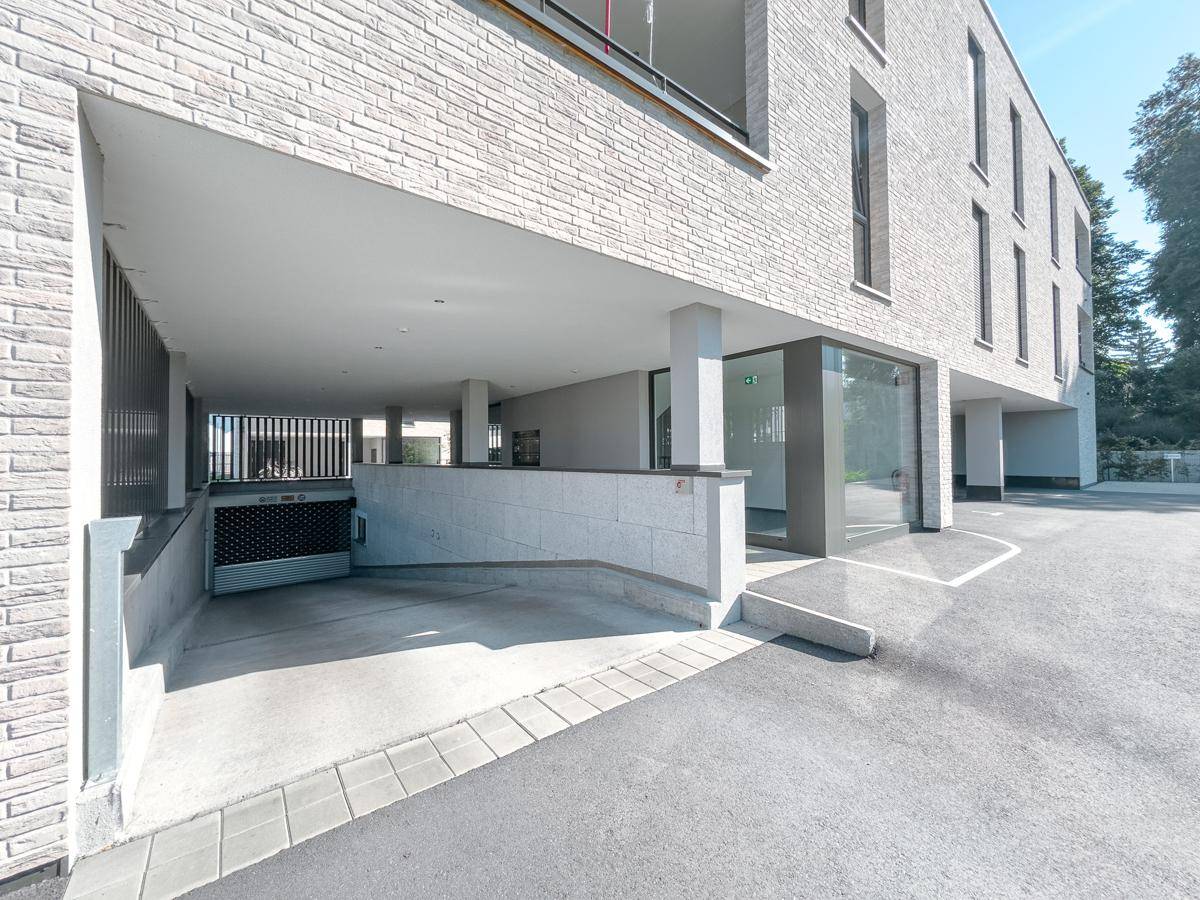 Tiefgaragenzufahrt und Eingangsbereich eines modernen Wohngebäudes mit barrierefreiem Zugang.