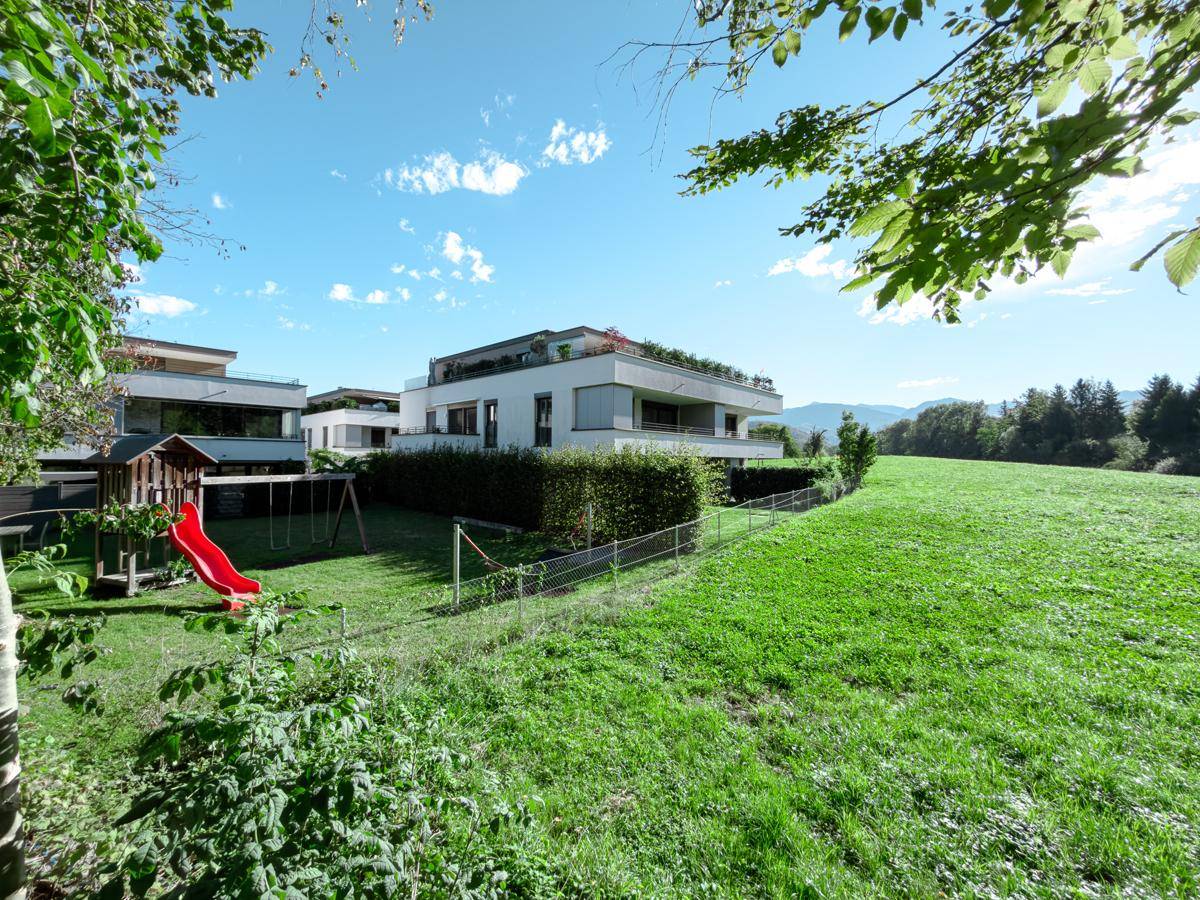 Weitläufiger Gartenbereich mit Spielplatz und Blick auf die umliegende Natur.