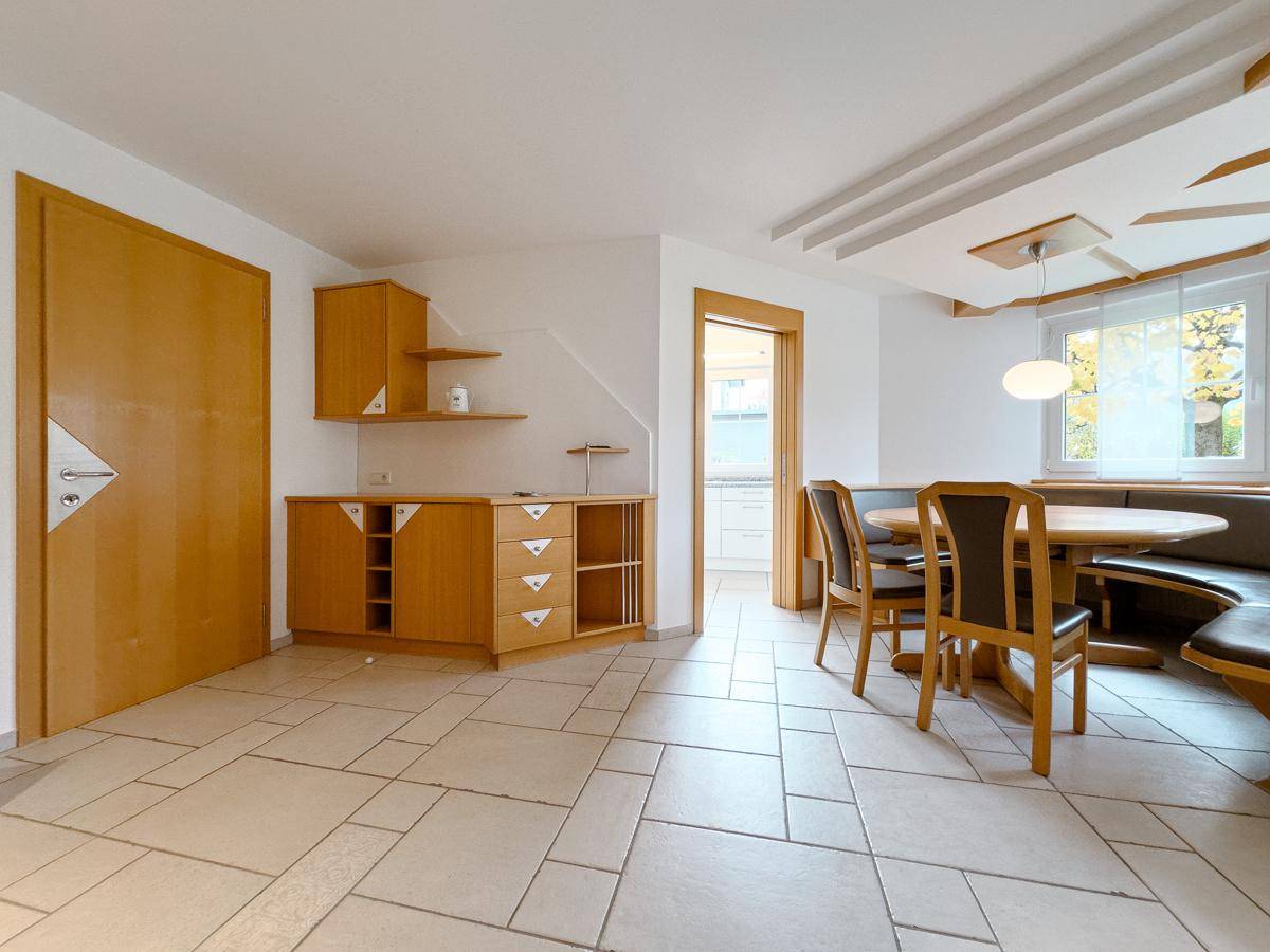 Gemütlicher Essbereich mit Holztisch, Eckbank und Zugang zur Küche.