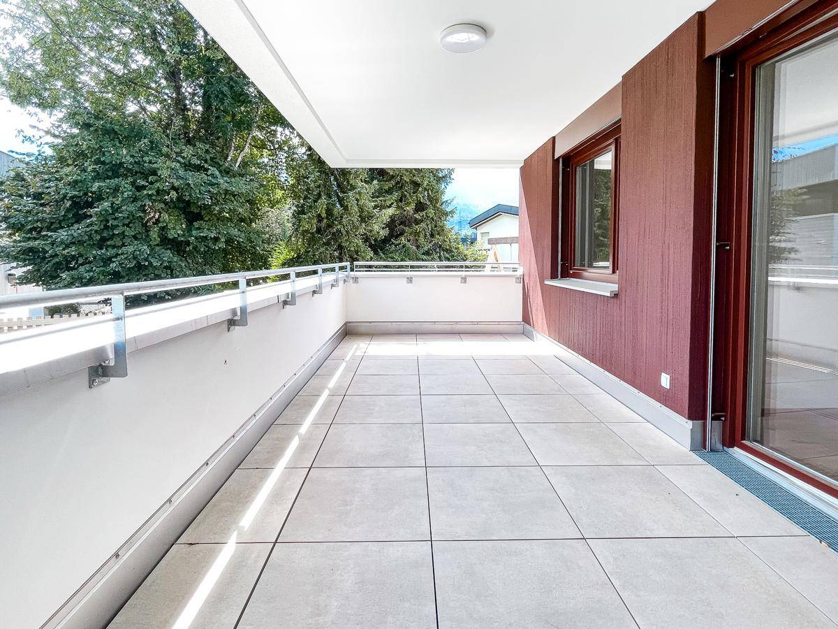 Geräumiger Balkon mit Fliesenboden und Metallgeländer, ideal für entspannte Stunden im Freien.