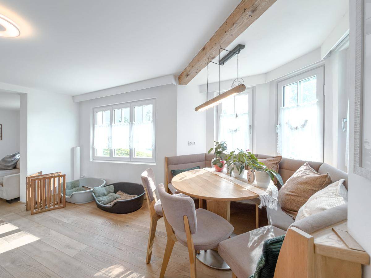 Heller Essbereich mit Holztisch und Eckbank, offen zum angrenzenden Wohnzimmer.