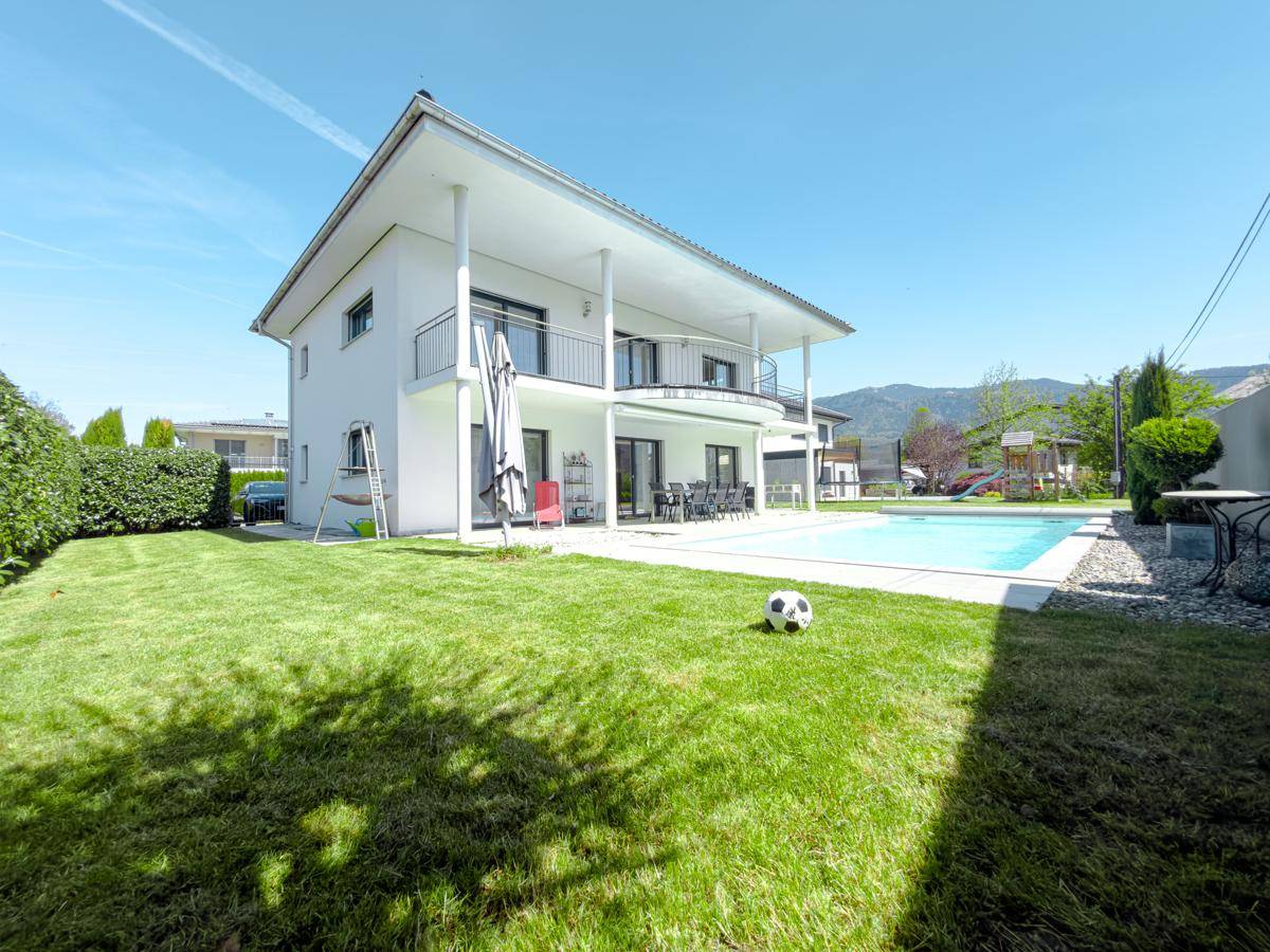 Großzügiger Gartenbereich mit Pool, Rasenfläche und Terrasse hinter dem Haus.