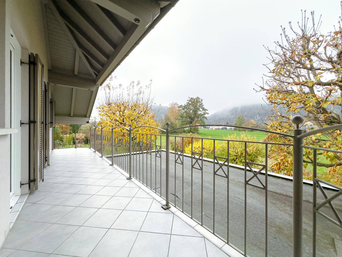 Langer Balkon mit Fliesenboden und Metallgeländer, bietet weiten Blick in die Landschaft.