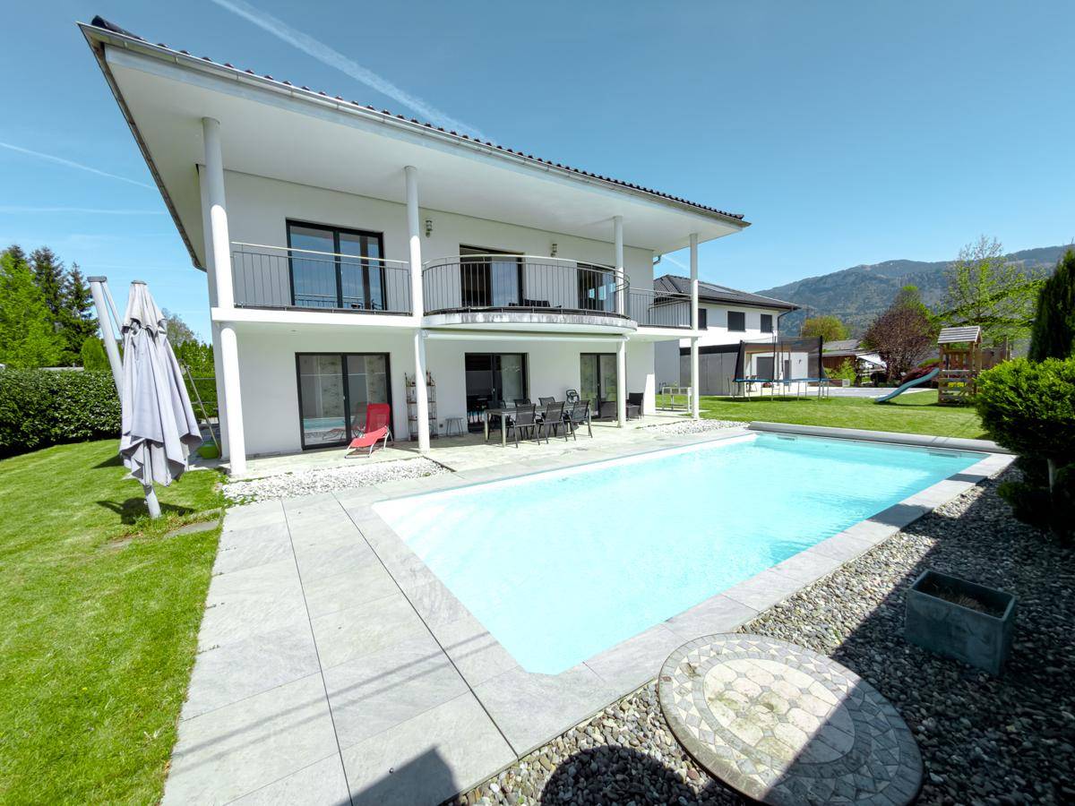Sonniger Garten mit Pool, Rasen und Terrasse, ideal für Entspannung im Freien.