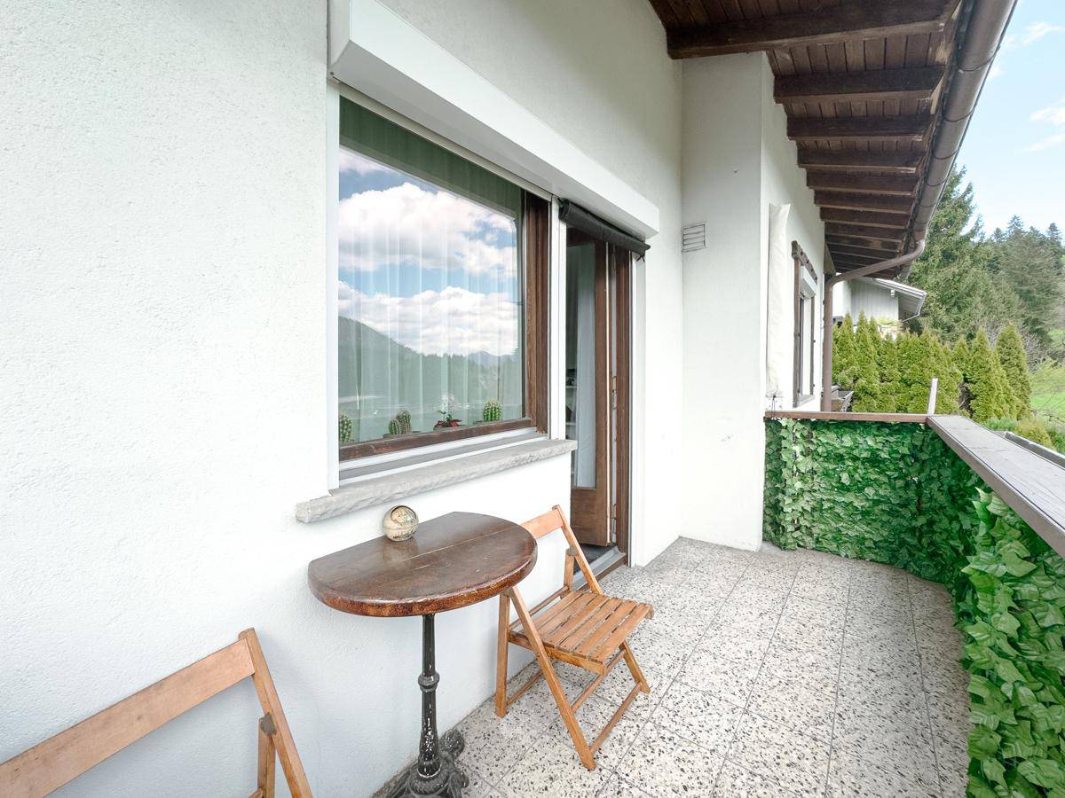 Kleiner Balkon mit Fliesenboden und Sitzgelegenheiten, ideal für eine Kaffeepause im Freien.