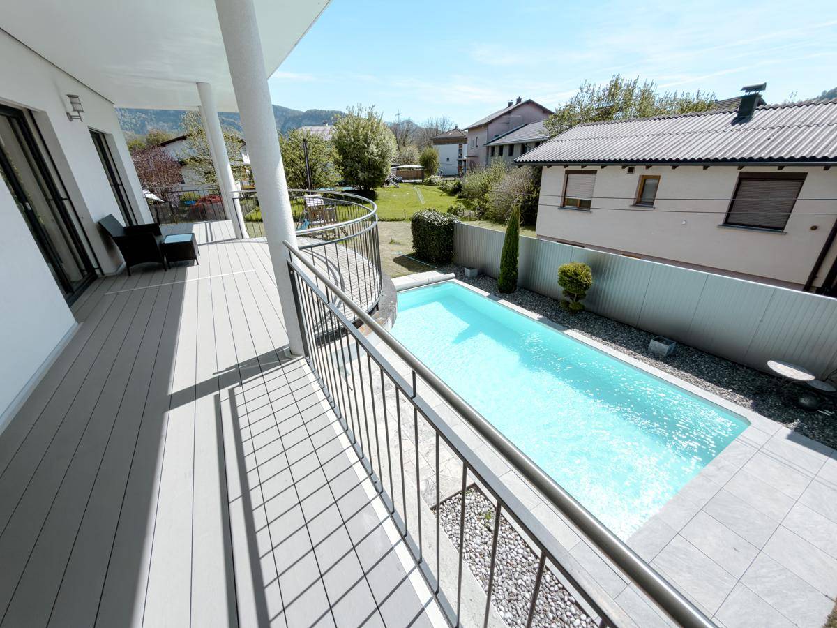 Großer Balkon mit Blick auf den Pool und die umliegende Landschaft, ideal zum Entspannen.