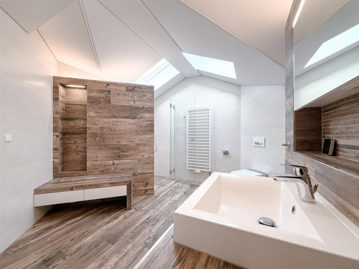 Modernes Badezimmer im Dachgeschoss mit Holzelementen, großer Dusche und Dachfenstern.