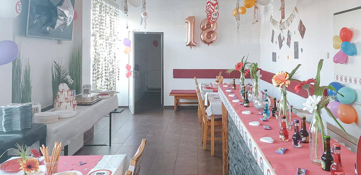 Großer Essbereich, festlich geschmückt mit Ballons und Blumen, bietet Platz für eine Veranstaltung mit Buffet.