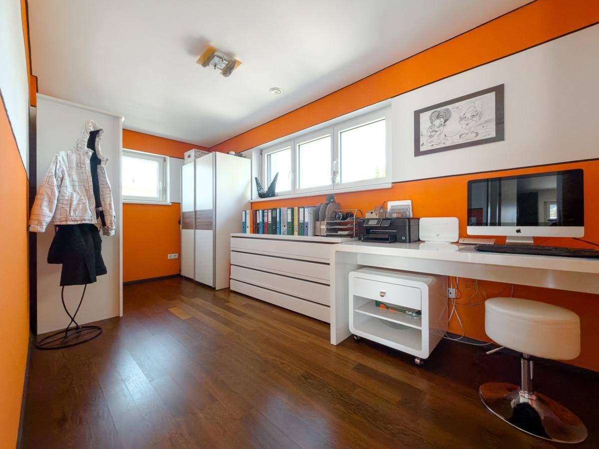 Geräumiges Büro mit Schreibtisch, Bürostuhl und Stauraum, ideal für Home-Office.
