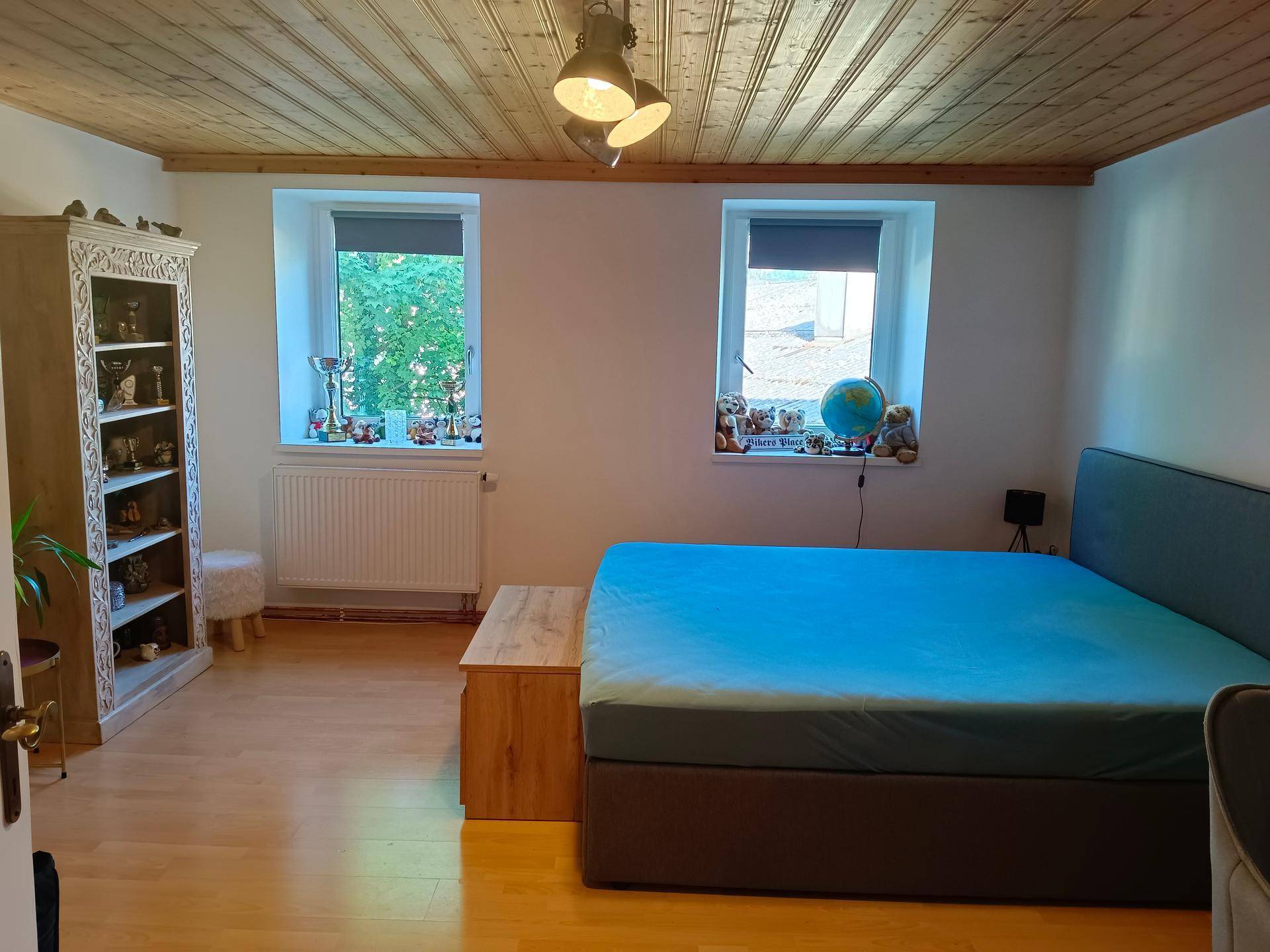 Gemütliches Schlafzimmer mit Holzbalkendecke, Parkettboden und einem großen Bett.