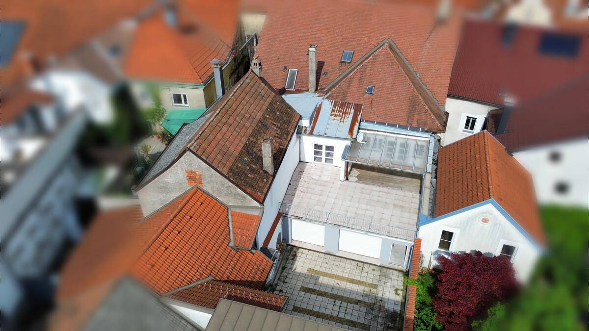 Luftaufnahme eines Gebäudekomplexes mit verschiedenen Dächern und einem Innenhofbereich.