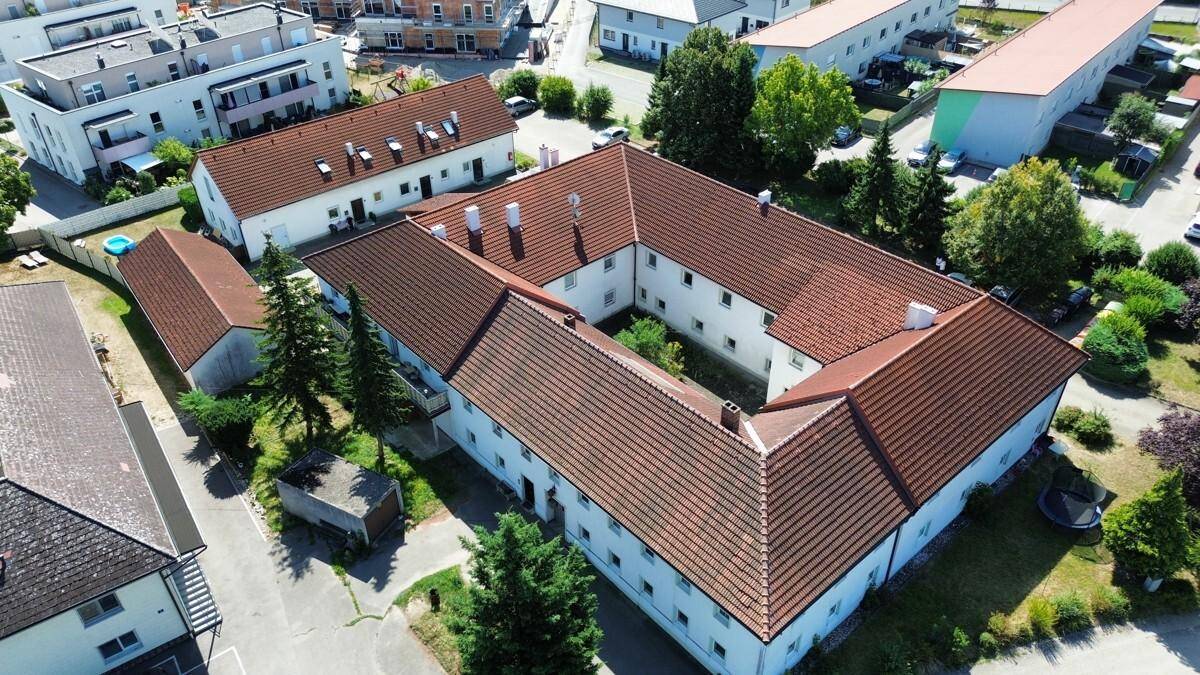 Übersicht aus der Vogelperspektive des Gebäudekomplexes mit roten Dächern und begrüntem Umfeld.
