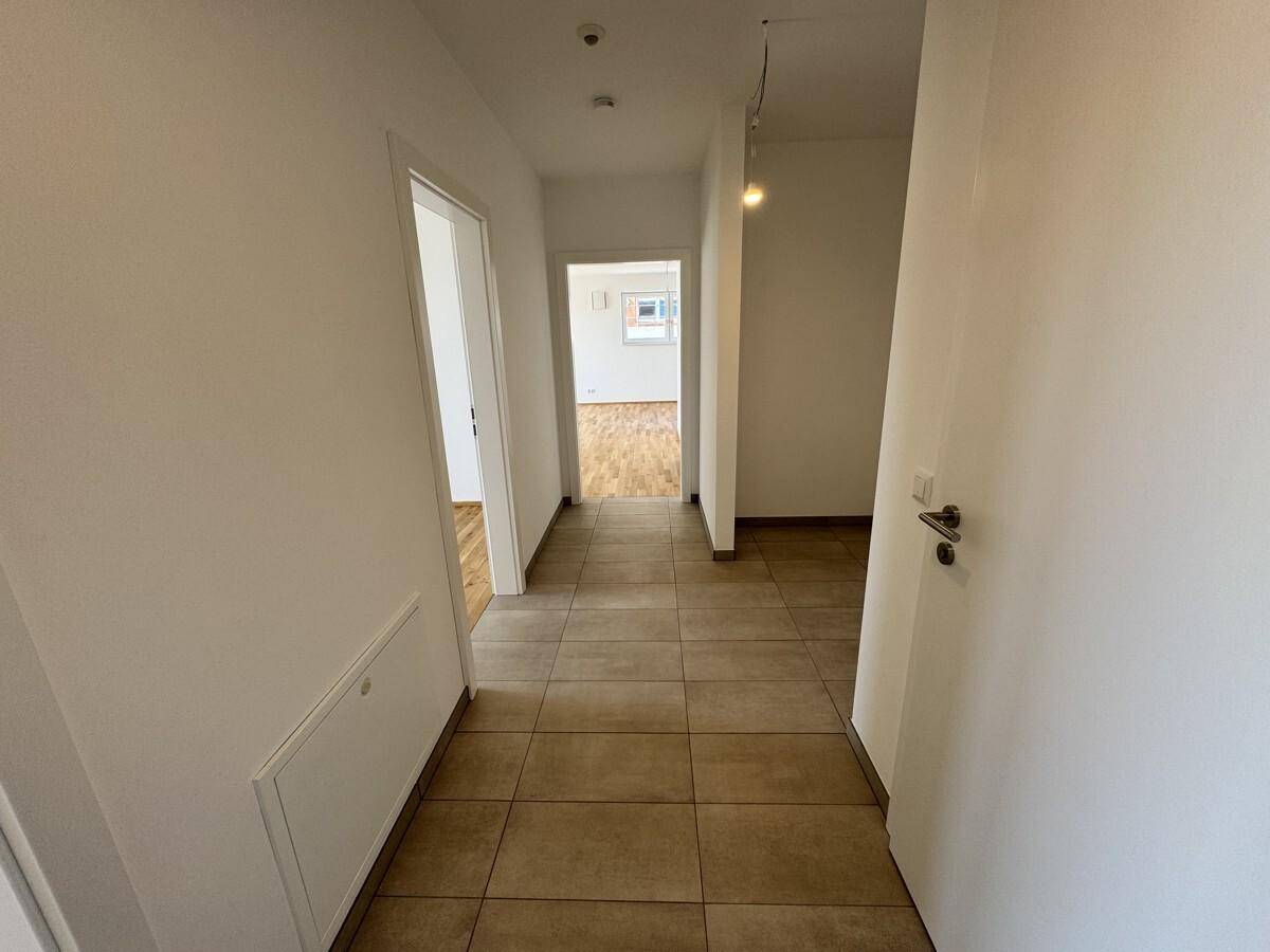 Flur mit Fliesenboden, der zu den verschiedenen Zimmern der Wohnung führt.