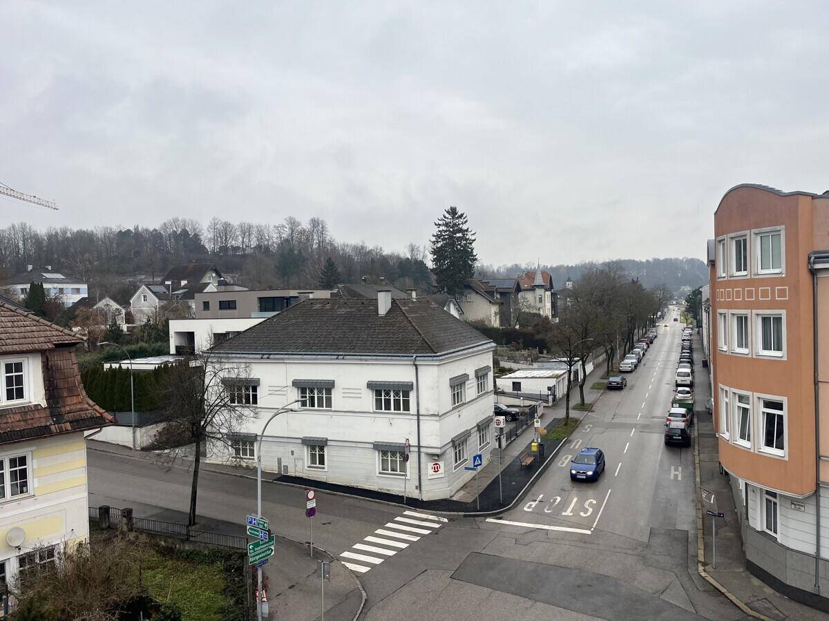 Panoramablick über die städtische Umgebung mit einer belebten Straße und umliegenden Häusern.