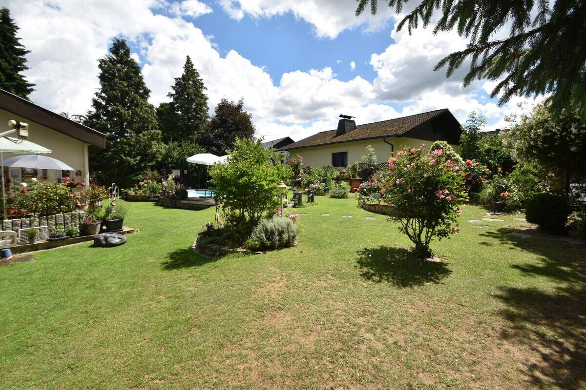 Großer, gepflegter Garten mit weitläufigen Rasenflächen und vielfältiger Bepflanzung.