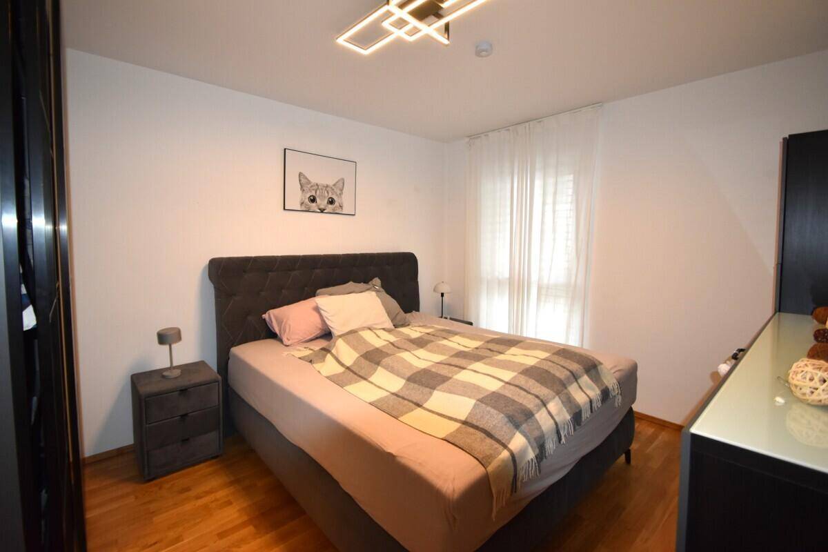 Gemütliches Schlafzimmer mit Doppelbett, Holzboden und großem Fenster.