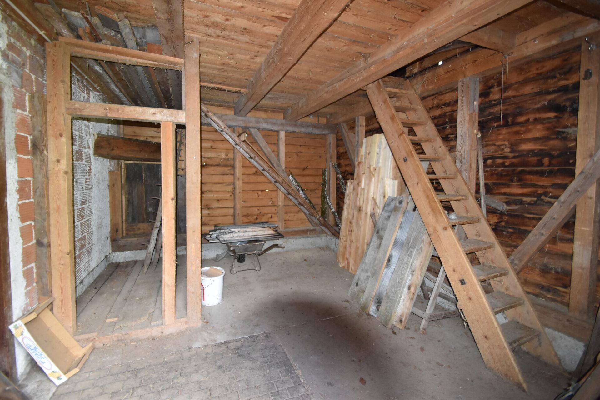 Unausgebauter Dachboden mit sichtbaren Holzbalken und Holzverkleidung, bietet viel Stauraum.