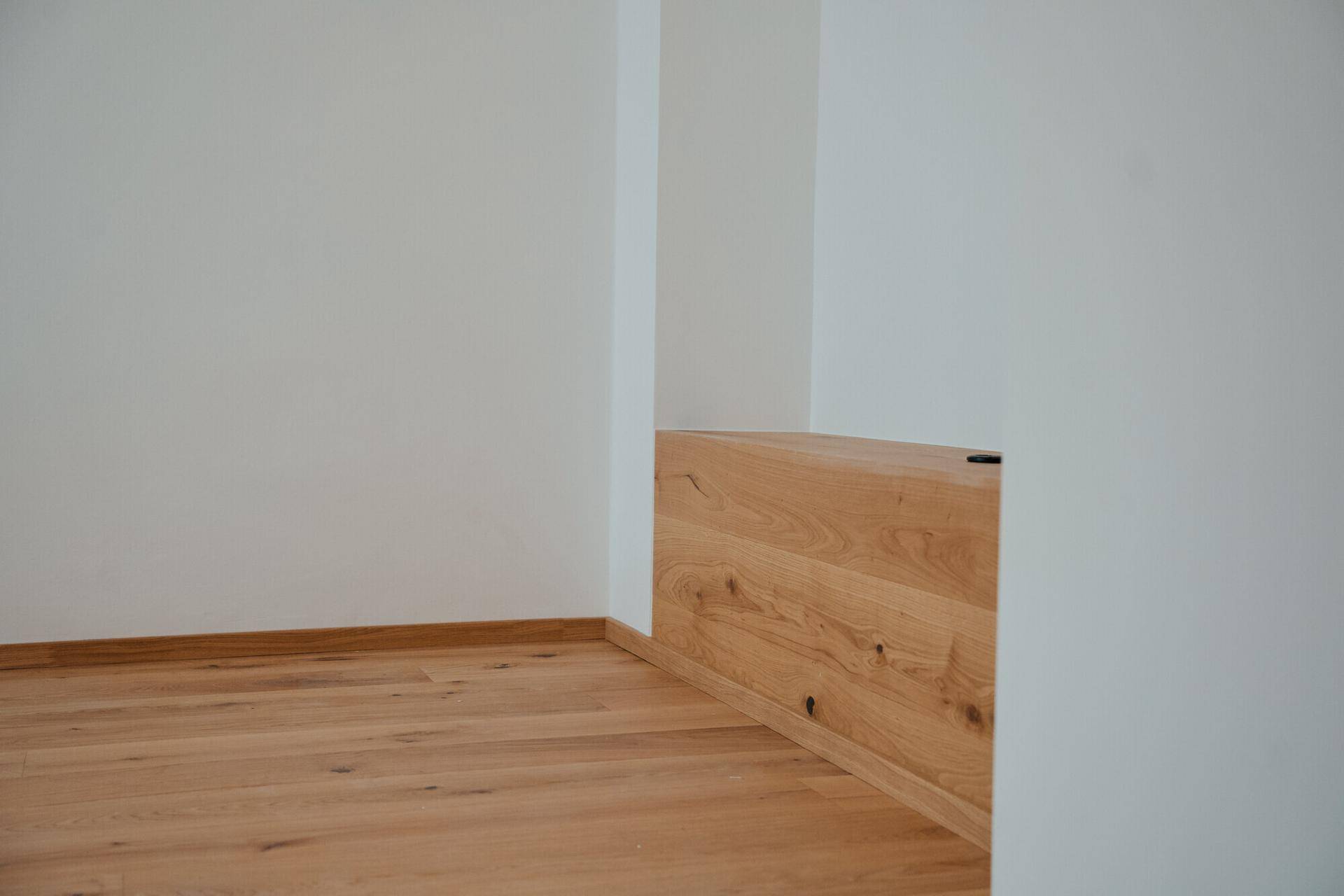 Detailansicht einer modernen Holzbank oder eines Stauraums mit hellem Holzboden.