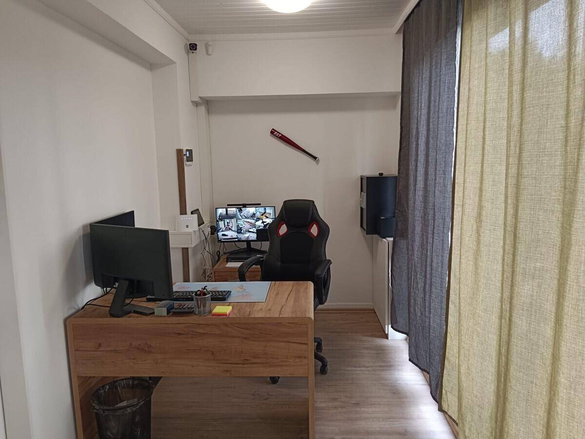Modern eingerichtetes Büro mit Holztisch, Bürostuhl und Laminatboden.