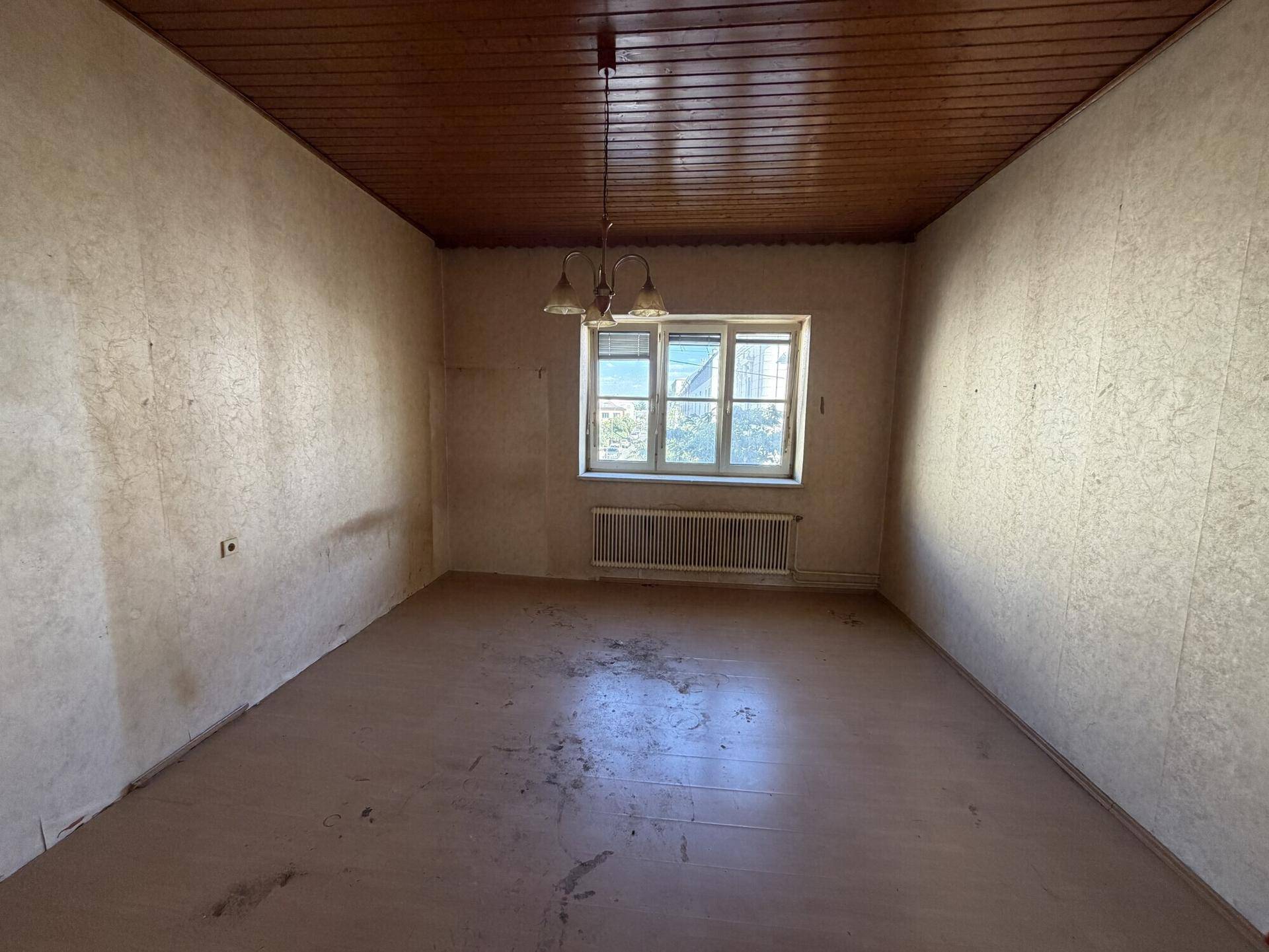 Geräumiger Raum mit Holzdecke und Laminatboden, bereit für eine individuelle Gestaltung.