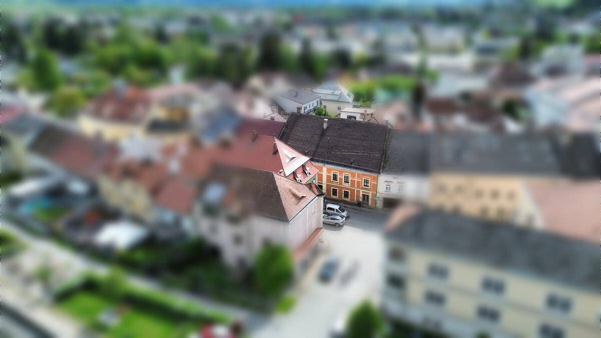 Luftaufnahme einer historischen Stadtansicht mit vielen Dächern und Gebäuden.