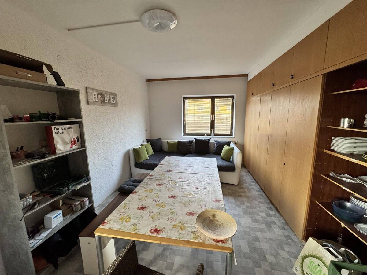 Esszimmer mit großem Tisch, Sitzbank und viel Stauraum in Einbauschränken.