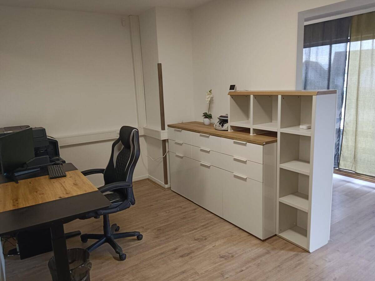 Büro mit modernen Möbeln, Stauraum und Zugang zu einem weiteren Raum.