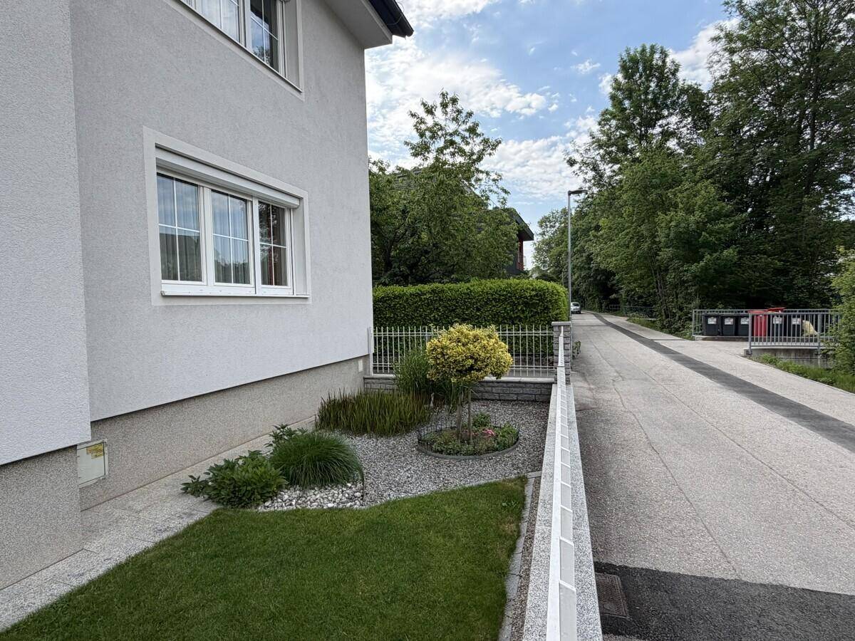 Seitenansicht des Hauses mit kleinem Ziergarten und Blick auf die ruhige Anliegerstraße.
