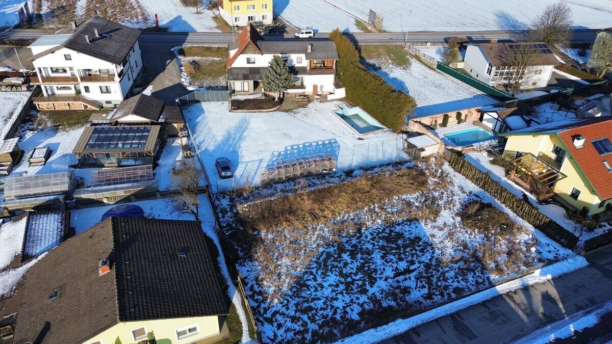 Luftaufnahme des Anwesens mit Haus, Pool und umliegender Landschaft im Winter.