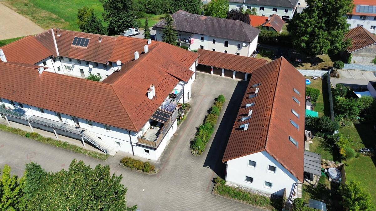 Luftbild des Gebäudekomplexes mit angrenzendem Nebengebäude und Parkflächen im Freien.