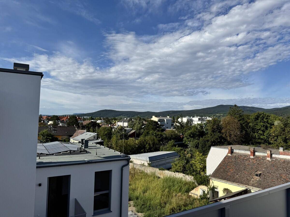 Weitläufiger Blick von der Dachterrasse über die Stadt und die grüne Landschaft.