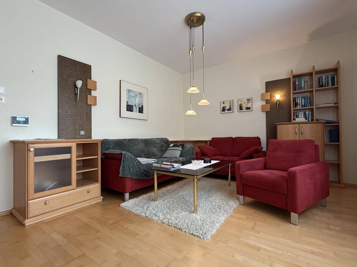Gemütliches Wohnzimmer mit Holzboden, bequemen Sofas und indirekter Beleuchtung.