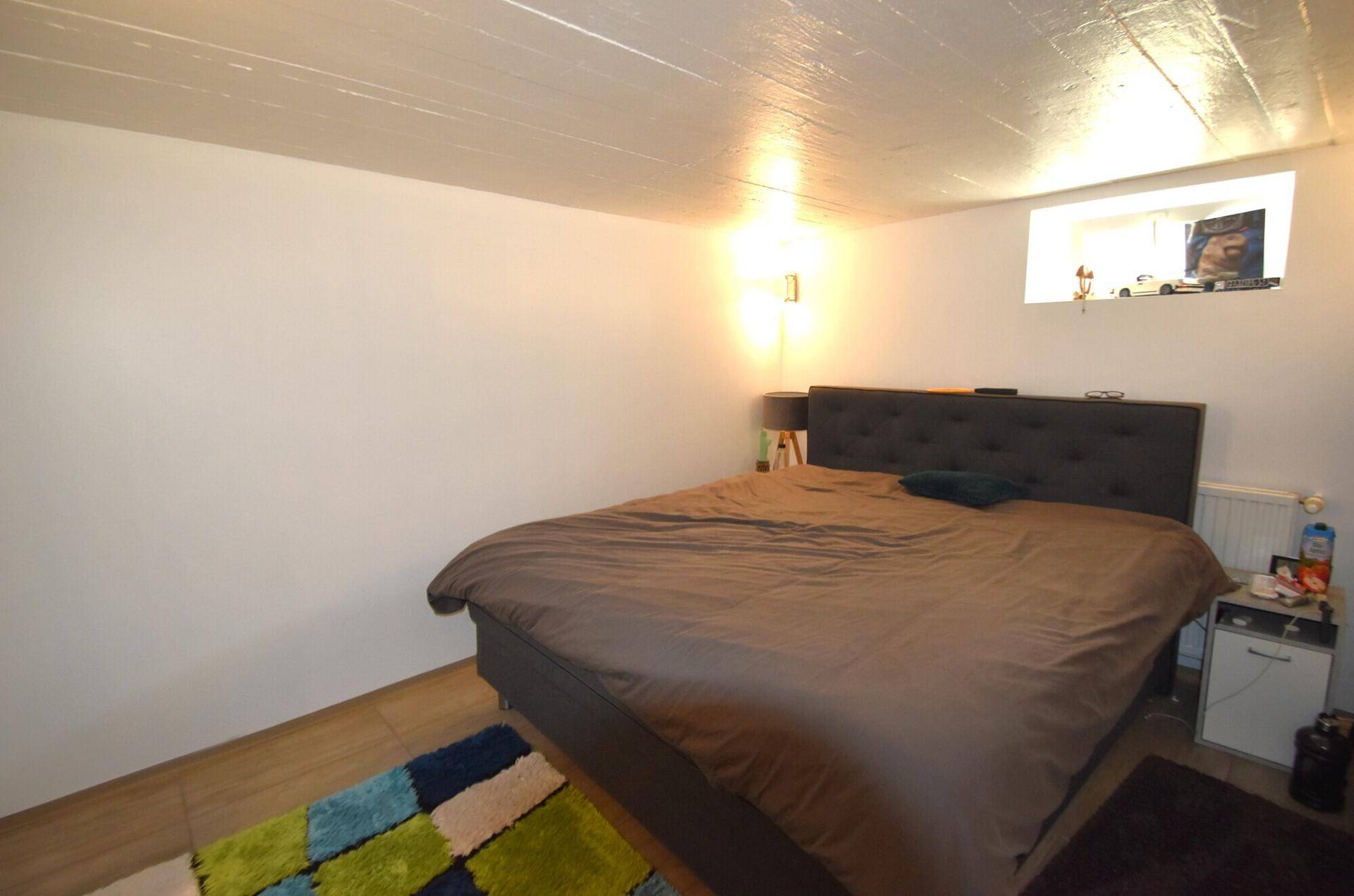 Schlafzimmer im Kellergeschoss mit Doppelbett und kleinem Fenster.