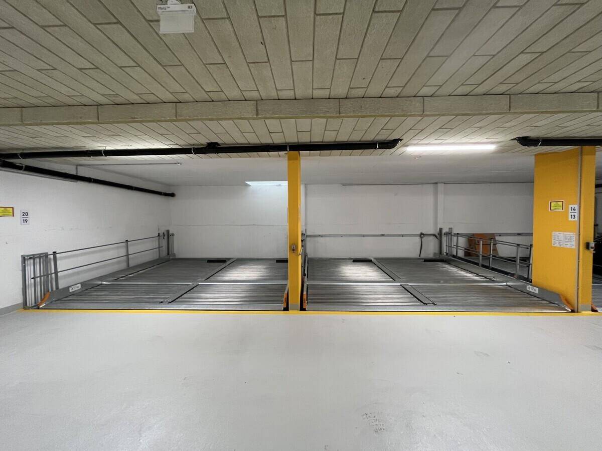 Tiefgarage mit Doppelparkern und hellen Markierungen, bietet sichere Stellplätze.
