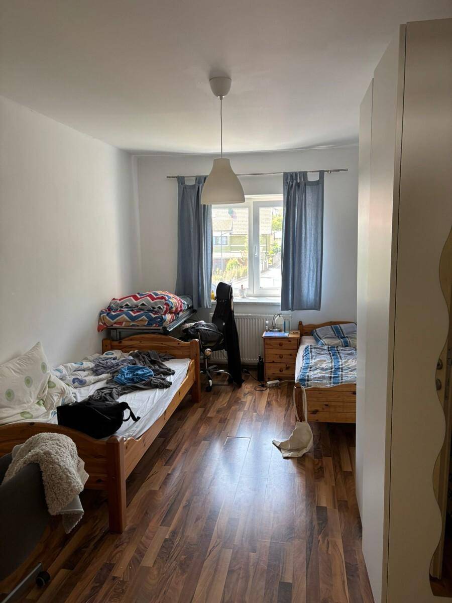 Geräumiges Schlafzimmer mit zwei Einzelbetten und einem Fenster mit Blick nach draußen.