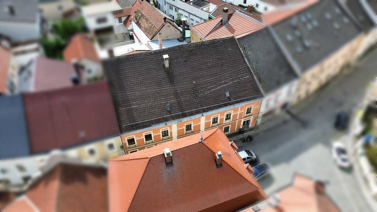Luftaufnahme einer historischen Stadtansicht mit vielen Dächern und Gebäuden.