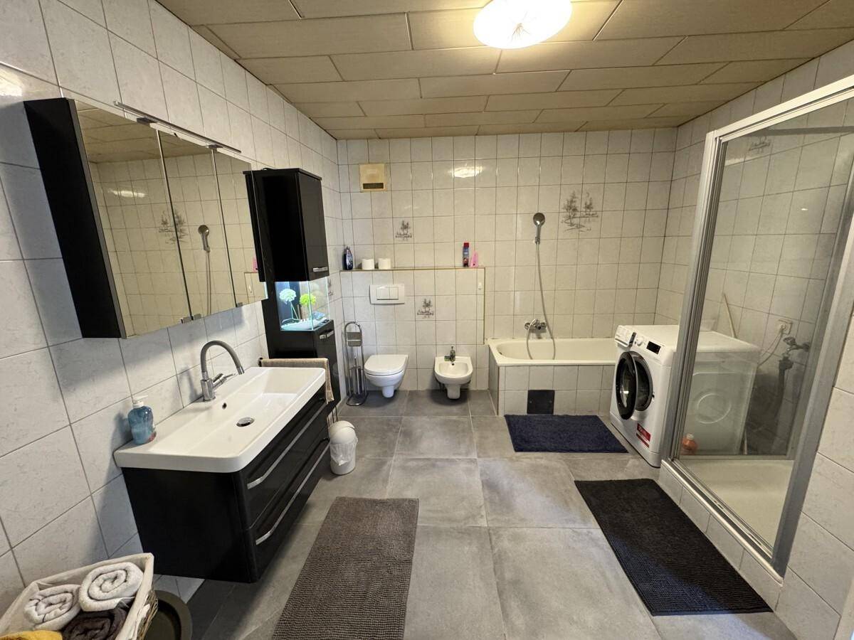 Geräumiges Badezimmer mit Badewanne, Dusche, Bidet und Waschmaschine.