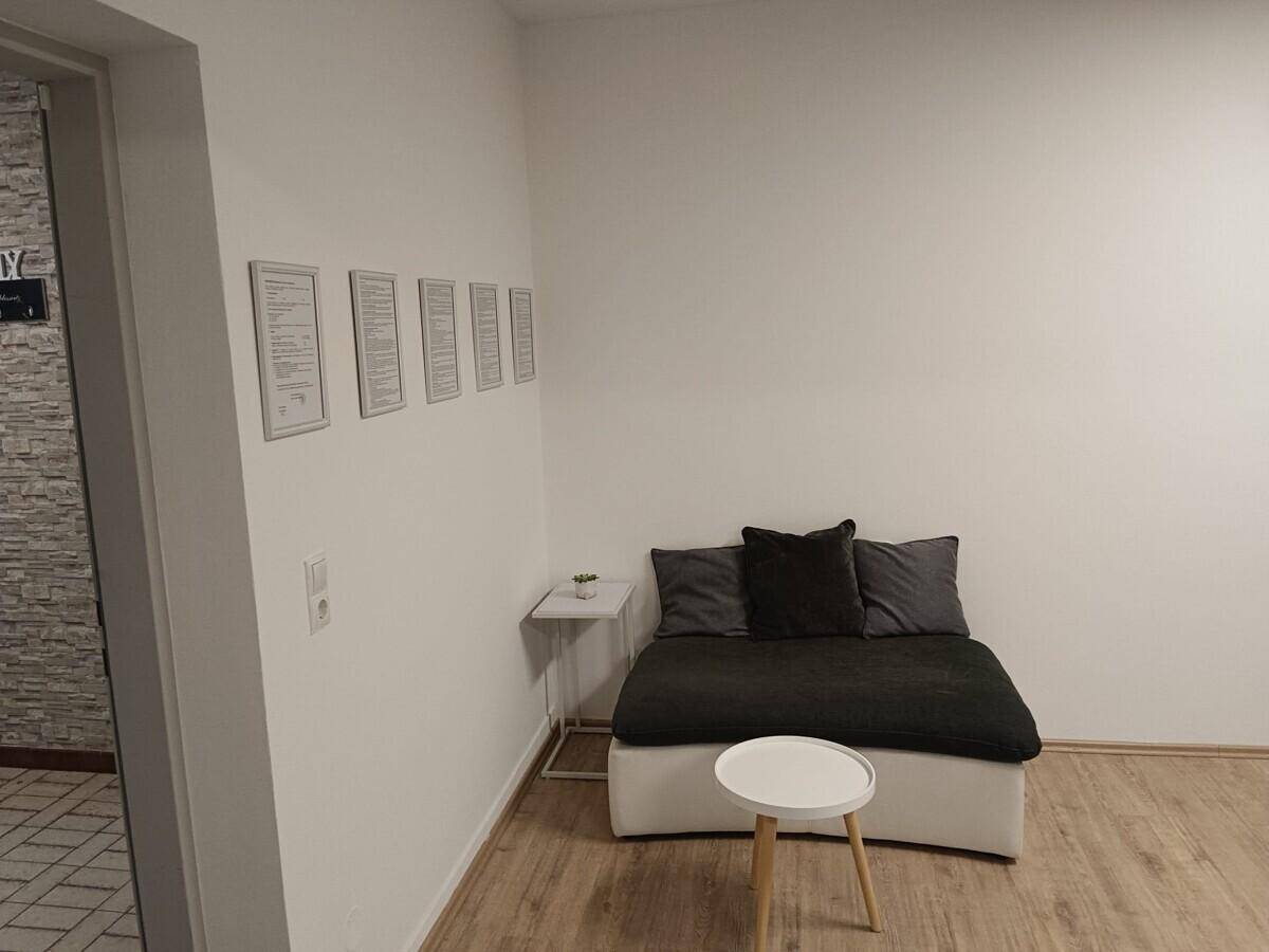 Wartebereich oder Empfang mit Sitzgelegenheit und Laminatboden.